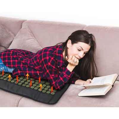  Image of a user lying on her tummy on the UTK heat pad