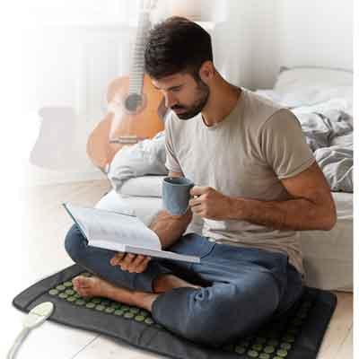 Image of a user sitting on a UTK Heating Pad